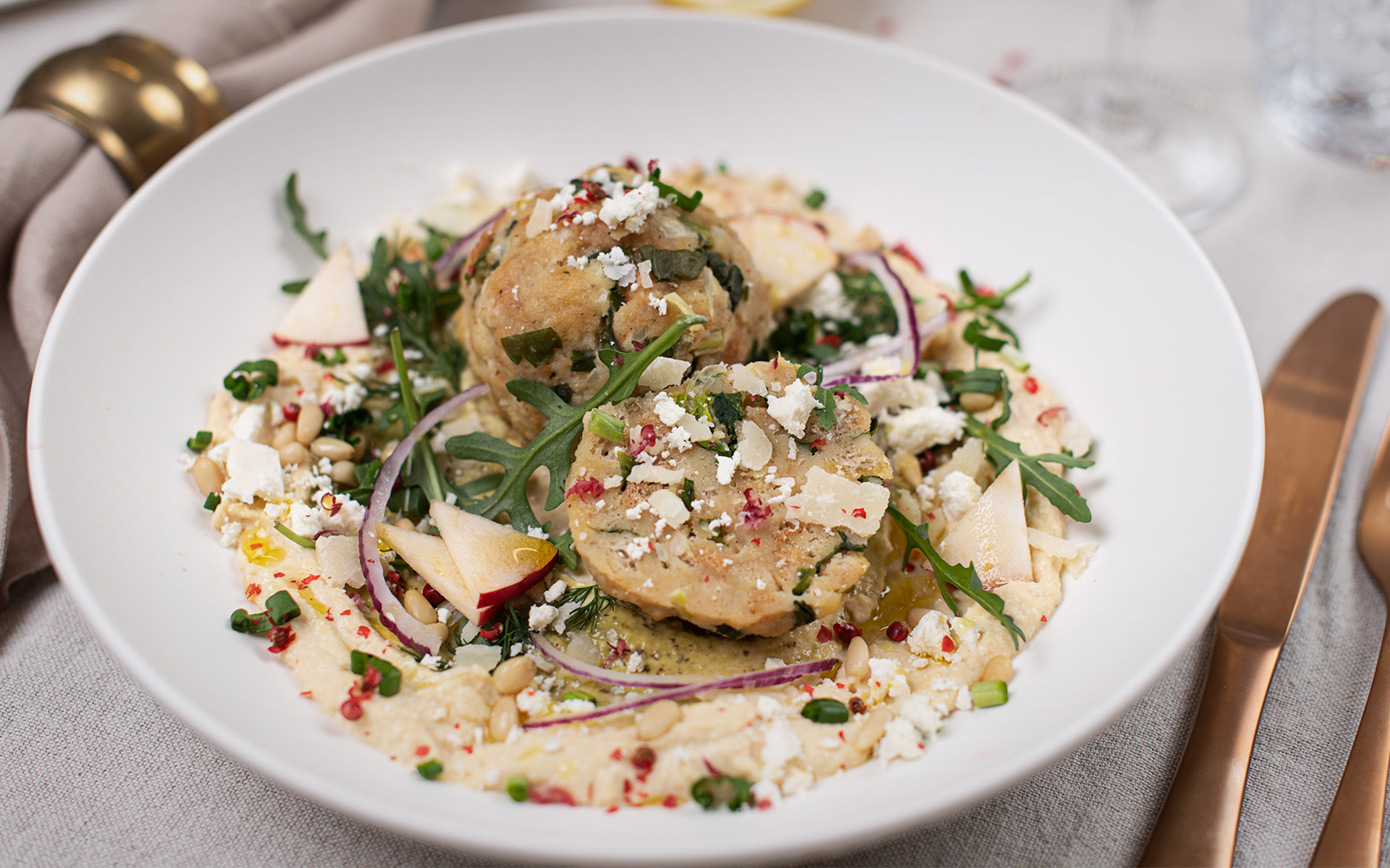 Würzige Bärlauchknödel auf einem bunten Salat mit Bärlauchcreme & Hummus